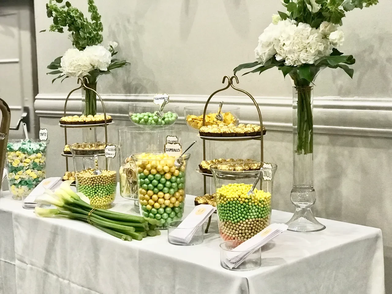 Elegant candy bar with white flowers and gold tiered stands