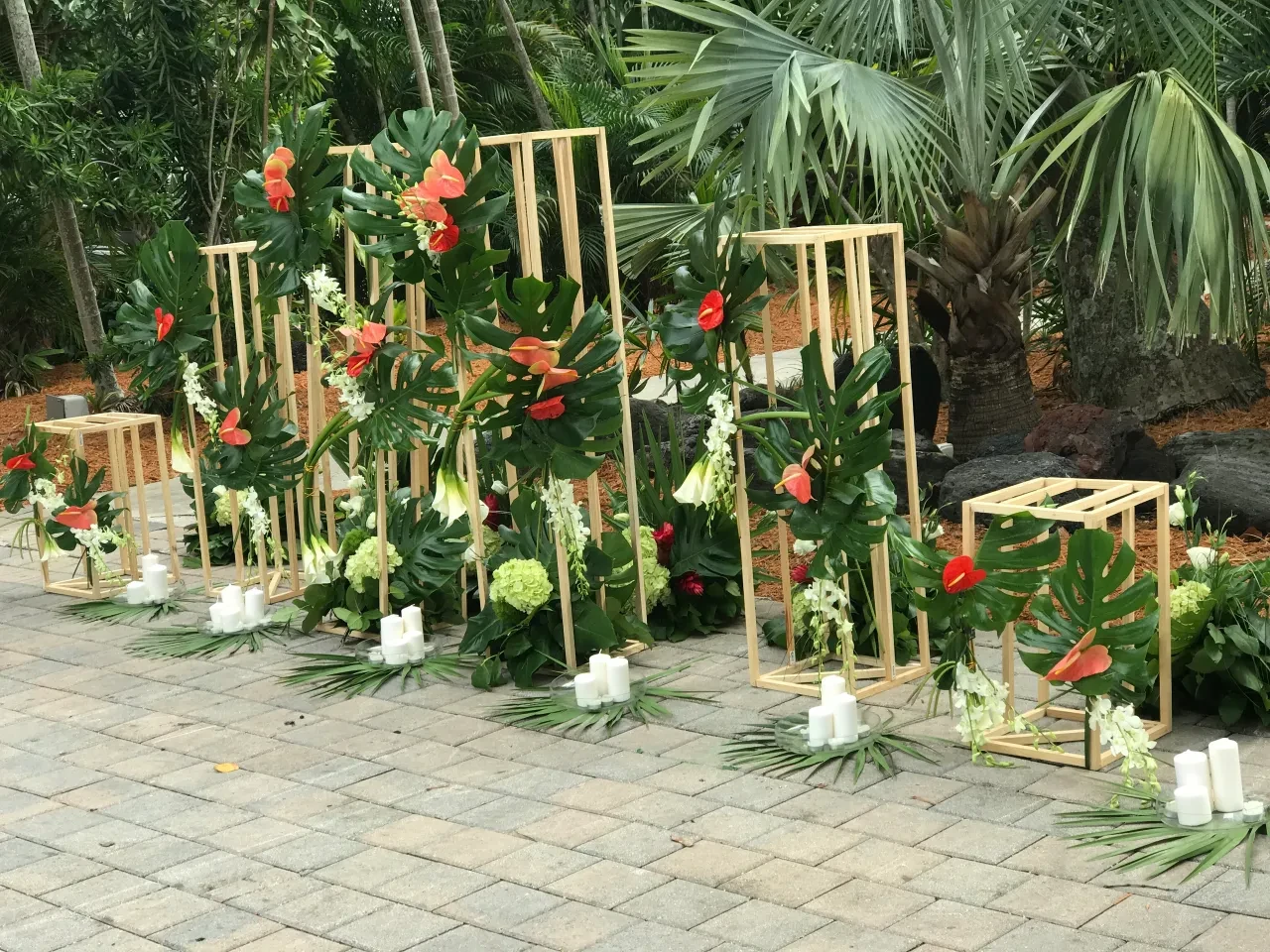 Tropical floral altar with anthurium monstera and gold geometric frames