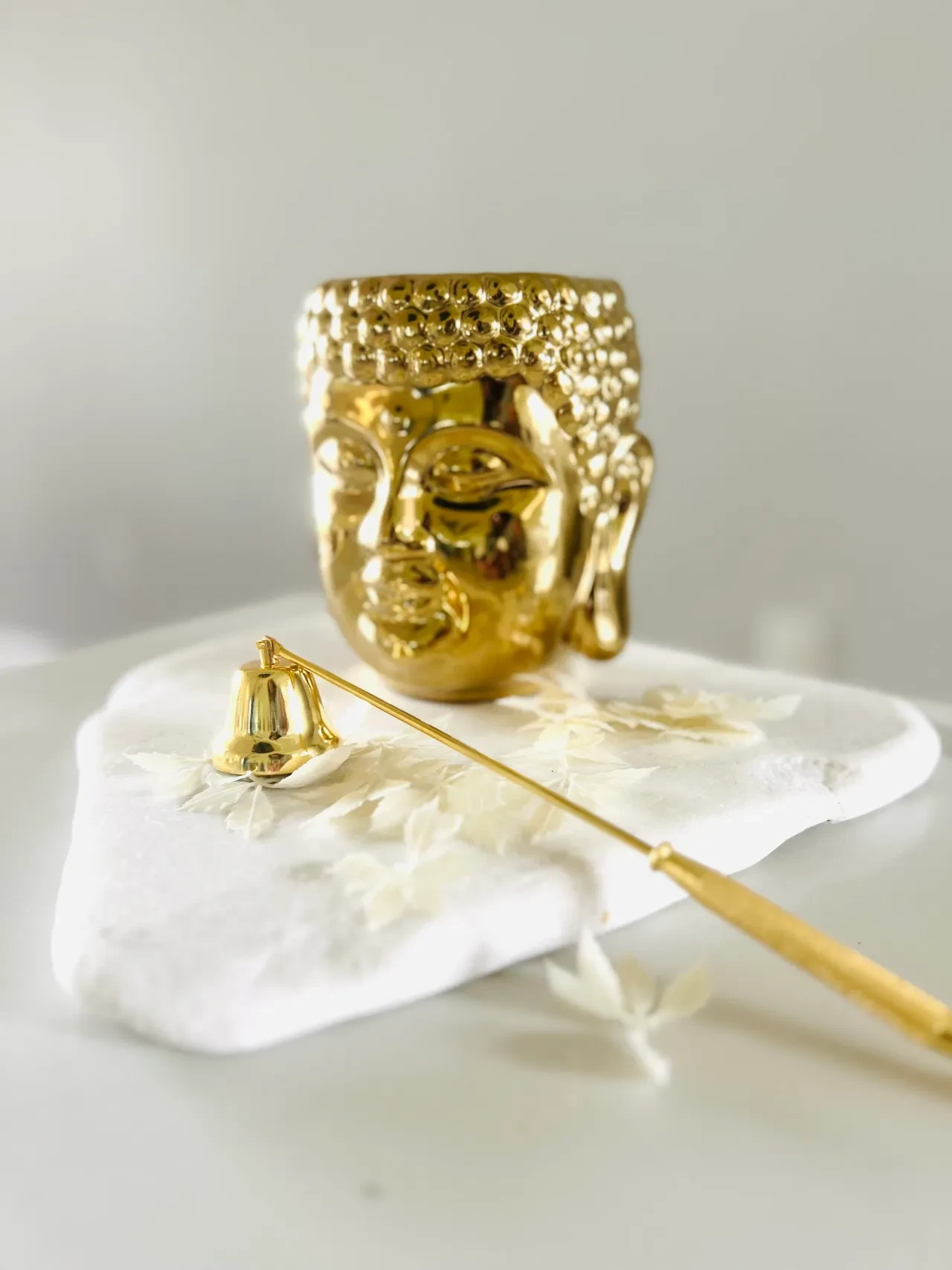 Gold Buddha head planter with incense holder on white selenite